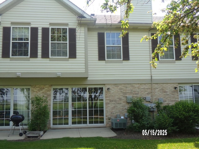 1926 Grove Ave, Schaumburg, IL 60193 - rear view of house with central AC, brick siding, and a patio