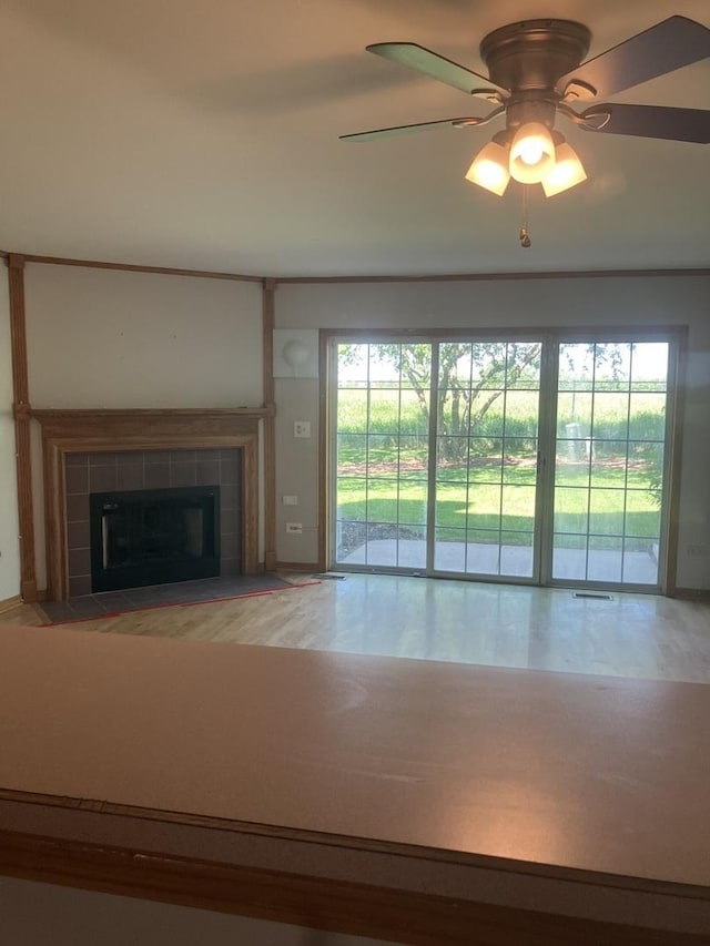 1926 Grove Ave, Schaumburg, IL 60193 - unfurnished living room featuring a ceiling fan, healthy amount of natural light, and a tiled fireplace