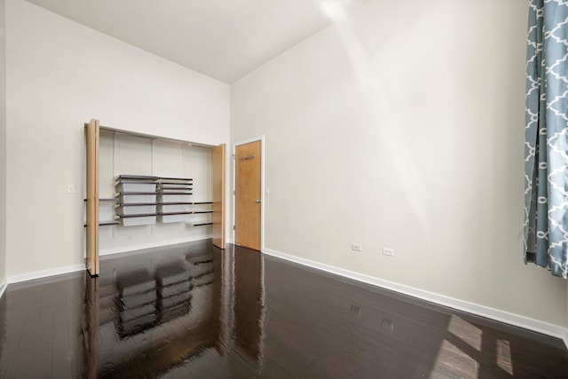 1935 S Archer Ave Unit 622, Chicago, IL 60616 - unfurnished bedroom with baseboards, dark wood-style floors, and a towering ceiling