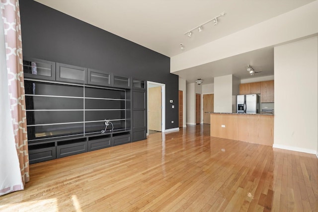 1935 S Archer Ave Unit 622, Chicago, IL 60616 - unfurnished living room featuring light wood-style flooring, track lighting, and baseboards