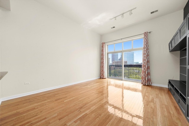 1935 S Archer Ave Unit 622, Chicago, IL 60616 - unfurnished living room featuring light wood-style floors, baseboards, and track lighting