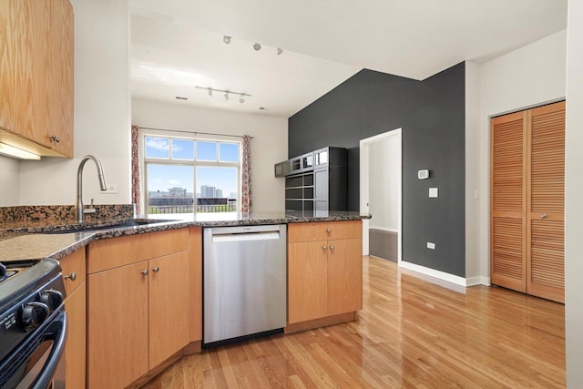 1935 S Archer Ave Unit 622, Chicago, IL 60616 - kitchen featuring stainless steel dishwasher, a sink, gas range, light wood-style flooring, and dark stone countertops