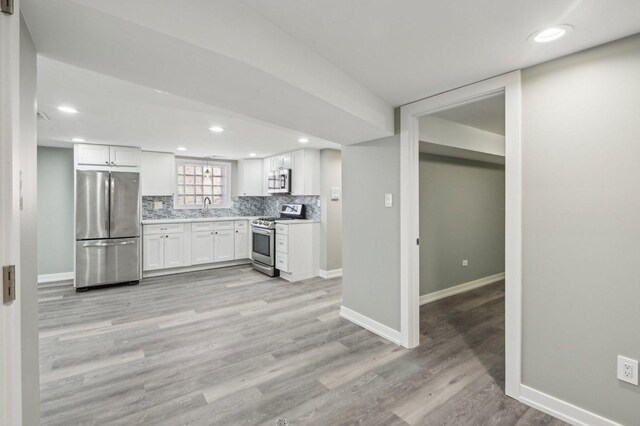 7801 S Honore St, Chicago, IL 60620 - kitchen with appliances with stainless steel finishes, a sink, baseboards, white cabinetry, and recessed lighting