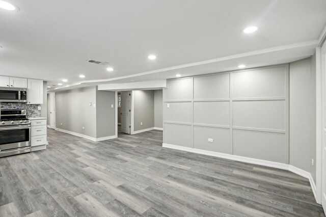 7801 S Honore St, Chicago, IL 60620 - kitchen with appliances with stainless steel finishes, light wood-style floors, backsplash, baseboards, and a decorative wall