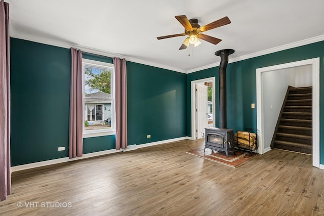 374 E Crystal Lake Ave, Crystal Lake, IL 60014 - unfurnished living room with a wood stove, ceiling fan, wood finished floors, baseboards, and crown molding