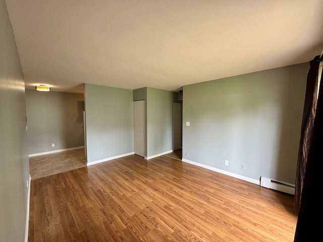 1900 Light Rd Unit 111, Oswego, IL 60543 - spare room with baseboard heating, wood finished floors, and baseboards