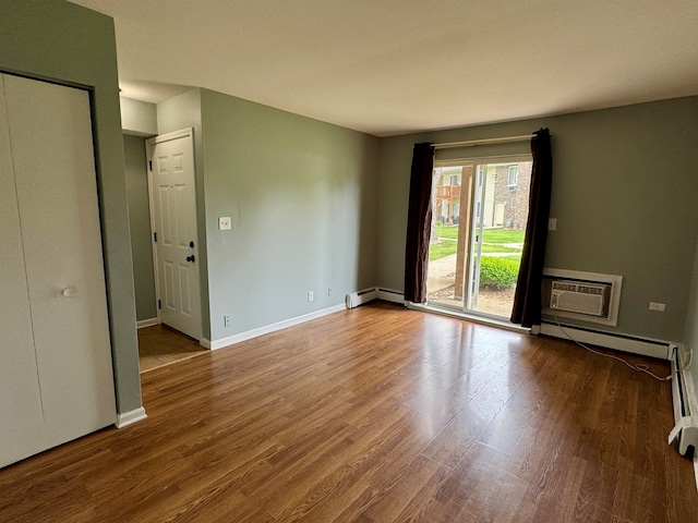 1900 Light Rd Unit 111, Oswego, IL 60543 - unfurnished room featuring a baseboard heating unit, wood finished floors, an AC wall unit, and baseboards