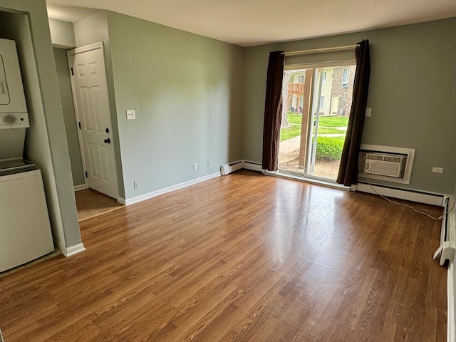 1900 Light Rd Unit 111, Oswego, IL 60543 - unfurnished room featuring a baseboard radiator, estacked washer and dryer, wood finished floors, and baseboards