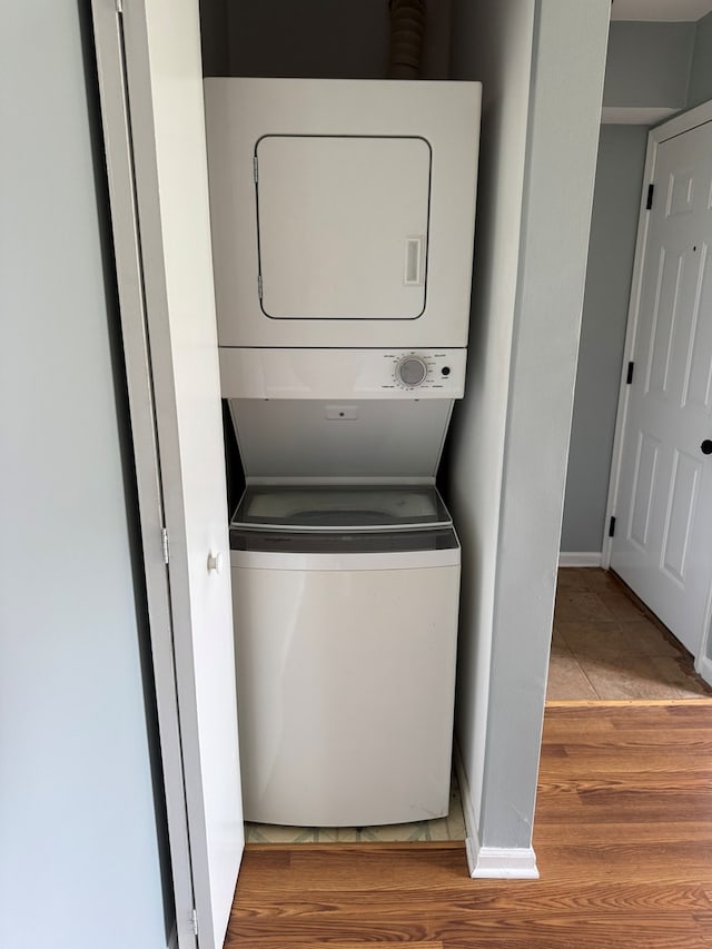 1900 Light Rd Unit 111, Oswego, IL 60543 - laundry area featuring stacked washer / drying machine, wood finished floors, and baseboards