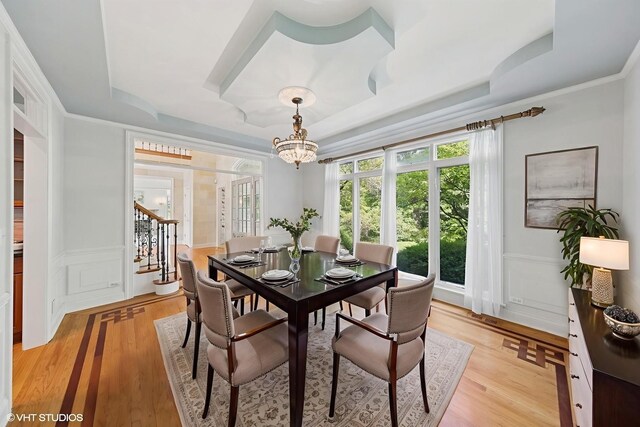 41W180 Highwood Ct, Elburn, IL 60119 - dining room with a raised ceiling, a chandelier, light wood-style flooring, stairway, and a decorative wall