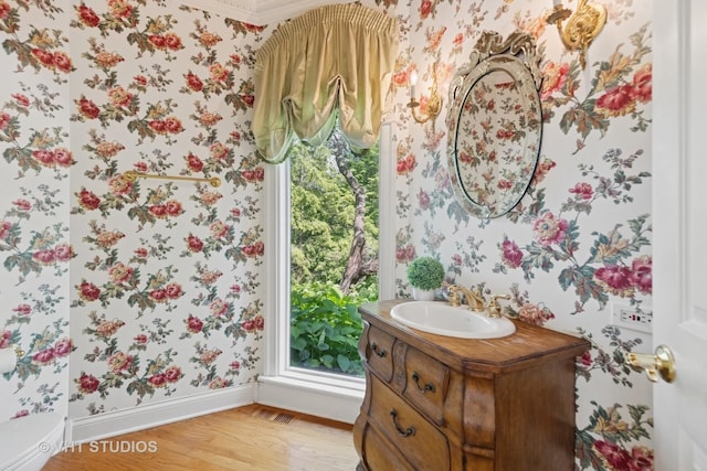 41W180 Highwood Ct, Elburn, IL 60119 - half bathroom with wallpapered walls, wood finished floors, vanity, and healthy amount of natural light