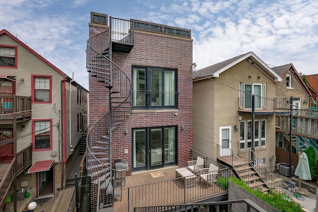 2128 N Winchester Ave, Chicago, IL 60614 - back of house with brick siding, central air condition unit, and stairway