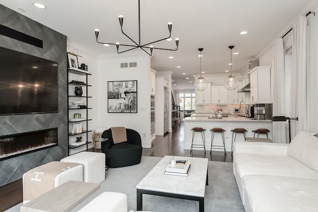 2128 N Winchester Ave, Chicago, IL 60614 - living area featuring dark wood-type flooring, ornamental molding, recessed lighting, a fireplace, and a chandelier