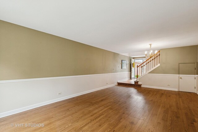 818 Kalamazoo Cir, Vernon Hills, IL 60061 - unfurnished living room with wood finished floors, a chandelier, stairs, and baseboards
