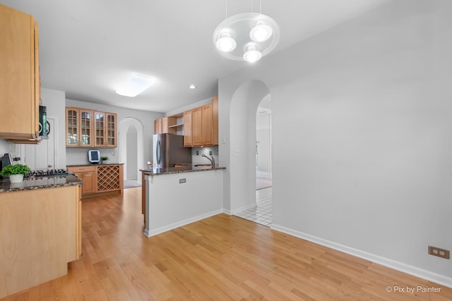 324 Torrington Dr, Bloomingdale, IL 60108 - kitchen with arched walkways, freestanding refrigerator, black microwave, light wood finished floors, and a sink