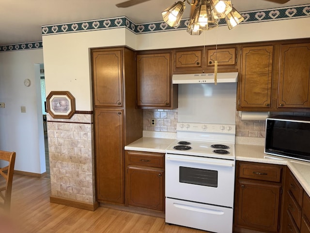 318 Durant St, Oglesby, IL 61348 - kitchen with white electric range oven, black microwave, ceiling fan, under cabinet range hood, and light countertops
