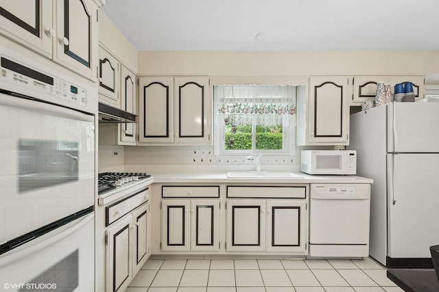 9047 Crawford Ave, Skokie, IL 60076 - kitchen featuring white appliances, a sink, light countertops, light tile patterned flooring, and decorative backsplash