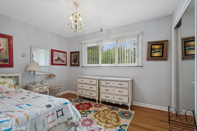 9047 Crawford Ave, Skokie, IL 60076 - bedroom featuring wood finished floors, a chandelier, baseboards, and a closet