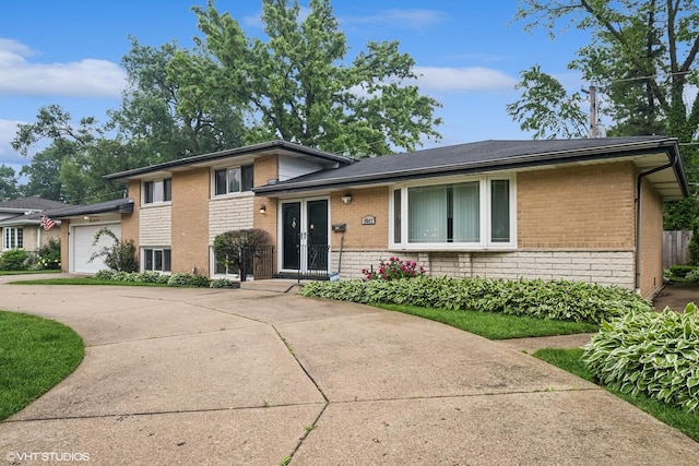 9047 Crawford Ave, Skokie, IL 60076 - split level home featuring brick siding, an attached garage, driveway, and french doors