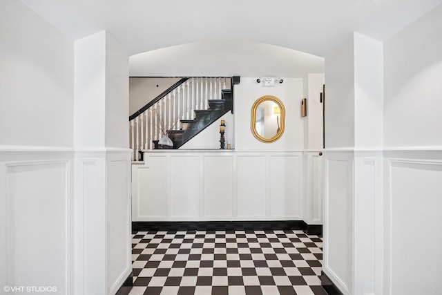 3120 N Sheridan Rd Unit A1, Chicago, IL 60657 - staircase featuring a decorative wall, arched walkways, a wainscoted wall, and tile patterned floors