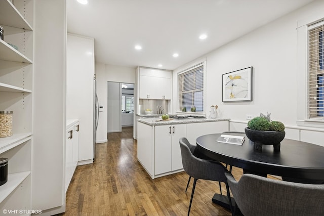 3120 N Sheridan Rd Unit A1, Chicago, IL 60657 - kitchen with white cabinetry, wood finished floors, light countertops, recessed lighting, and a peninsula
