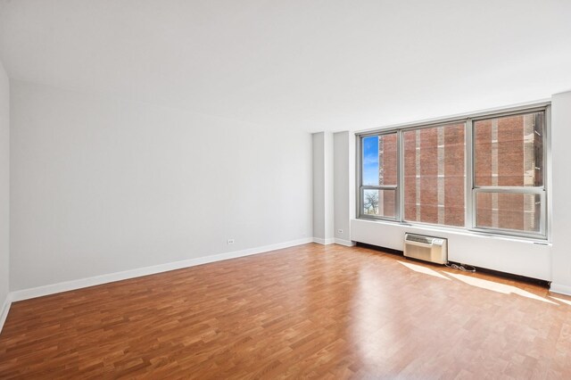 1550 N Lake Shore Dr Unit 7D, Chicago, IL 60610 - unfurnished room featuring wood finished floors, an AC wall unit, and baseboards