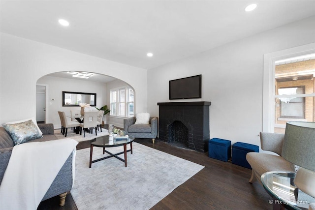 4846 W Roscoe St, Chicago, IL 60641 - living area with arched walkways, dark wood-style floors, recessed lighting, and a fireplace