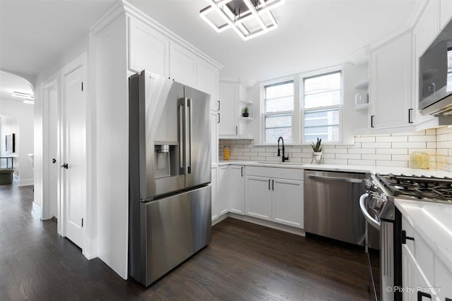 4846 W Roscoe St, Chicago, IL 60641 - kitchen featuring stainless steel appliances, a sink, open shelves, and dark wood finished floors