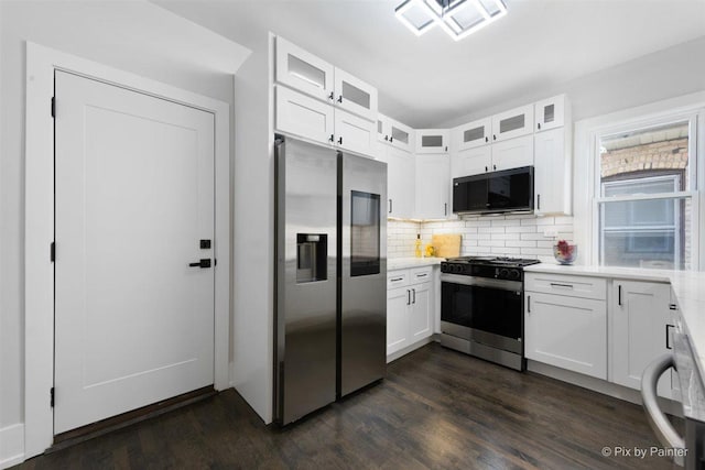 4846 W Roscoe St, Chicago, IL 60641 - kitchen with stainless steel appliances, light countertops, white cabinets, and dark wood-type flooring