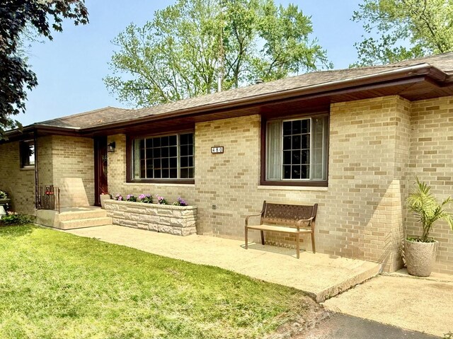 480 W Kennedy Rd, Braidwood, IL 60408 - view of exterior entry featuring a lawn and brick siding