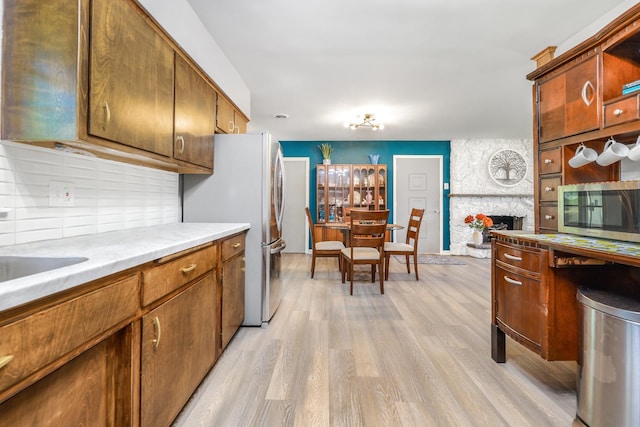 480 W Kennedy Rd, Braidwood, IL 60408 - kitchen featuring stainless steel appliances, light wood-type flooring, light countertops, brown cabinetry, and tasteful backsplash