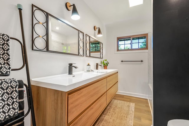 480 W Kennedy Rd, Braidwood, IL 60408 - bathroom featuring wood finished floors, double vanity, baseboards, and tub / shower combination
