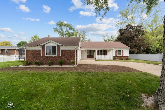 1245 W Lotus Ln, Kankakee, IL 60901 - single story home featuring a trampoline, brick siding, driveway, and covered porch