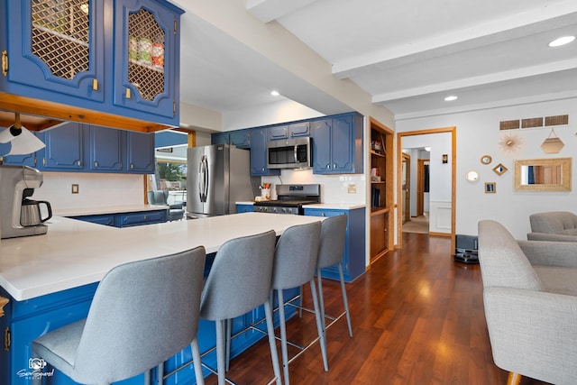 1245 W Lotus Ln, Kankakee, IL 60901 - kitchen with stainless steel appliances, blue cabinets, a peninsula, beamed ceiling, and light countertops