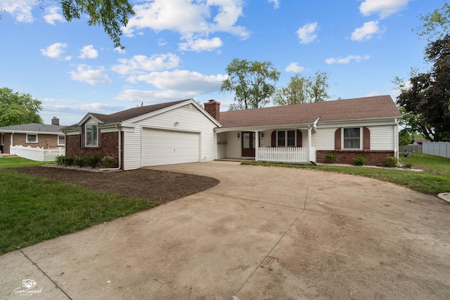 1245 W Lotus Ln, Kankakee, IL 60901 - ranch-style house with covered porch, brick siding, driveway, a chimney, and a garage