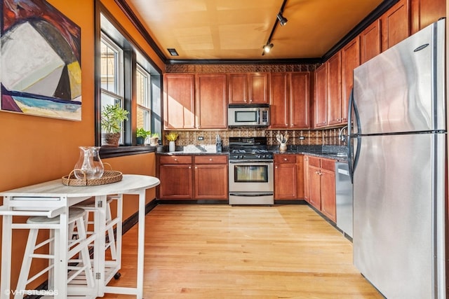 4337 N Troy St Unit 3W, Chicago, IL 60618 - kitchen with stainless steel appliances, rail lighting, light wood finished floors, tasteful backsplash, and brown cabinetry