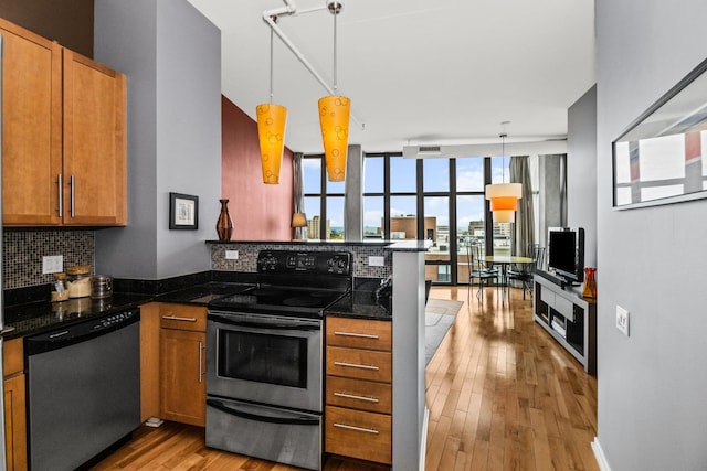 1000 W Leland St Unit 9B, Chicago, IL 60640 - kitchen with appliances with stainless steel finishes, a peninsula, backsplash, light wood-style floors, and pendant lighting