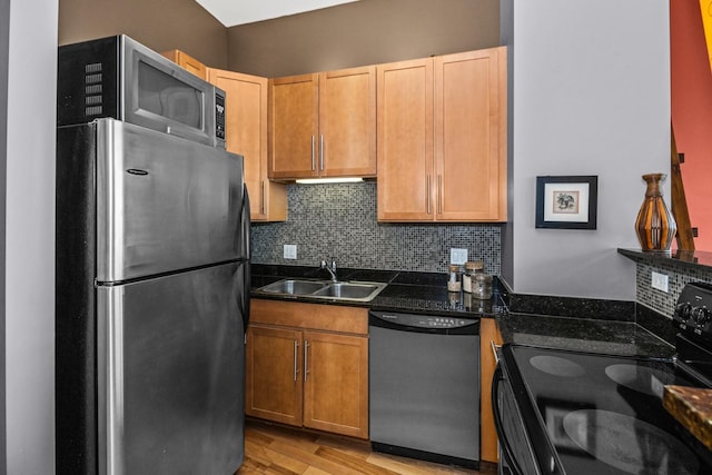 1000 W Leland St Unit 9B, Chicago, IL 60640 - kitchen with stainless steel appliances, a sink, dark countertops, backsplash, and light wood-style flooring