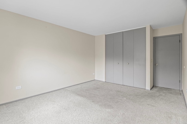 2420 E Brandenberry Ct Unit 2F, Arlington Heights, IL 60004 - unfurnished bedroom featuring light colored carpet, a closet, and baseboards