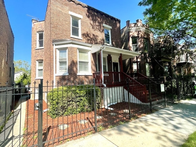 1426 N Central Park Ave, Chicago, IL 60651 - view of front of home featuring brick siding, a fenced front yard, and covered porch