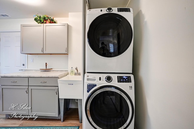 1109 Needham Rd, Naperville, IL 60563 - washroom featuring stacked washer and clothes dryer, cabinet space, and wood finished floors