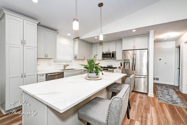 1109 Needham Rd, Naperville, IL 60563 - kitchen with appliances with stainless steel finishes, a sink, lofted ceiling, light wood finished floors, and light stone counters