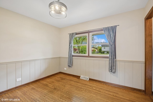 2020 Rolling Ridge Ln, Lindenhurst, IL 60046 - empty room featuring light wood-style floors and a wainscoted wall