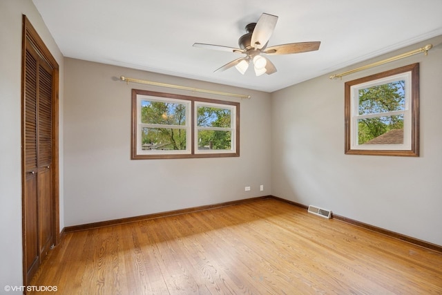 2020 Rolling Ridge Ln, Lindenhurst, IL 60046 - unfurnished bedroom featuring multiple windows, a closet, baseboards, and light wood-type flooring