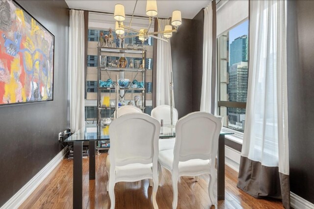 55 E Erie Ave Unit 1504, Chicago, IL 60611 - dining area with a chandelier, baseboards, and wood finished floors
