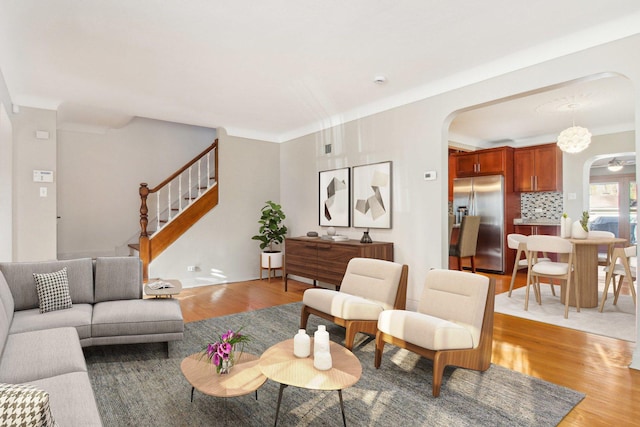 38 Northgate Rd, Riverside, IL 60546 - living room featuring arched walkways, light wood-type flooring, and stairs
