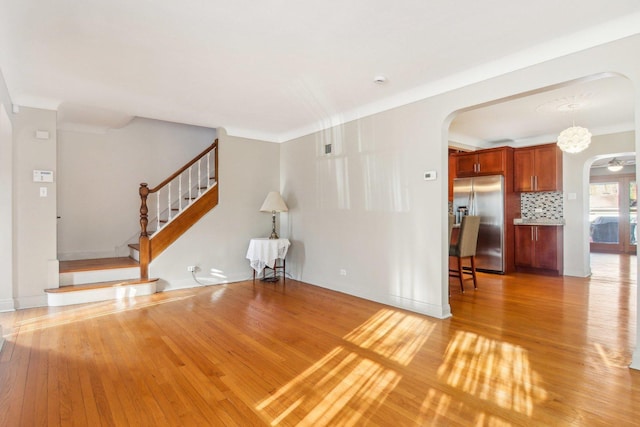 38 Northgate Rd, Riverside, IL 60546 - unfurnished living room with arched walkways, light wood-style flooring, and stairway