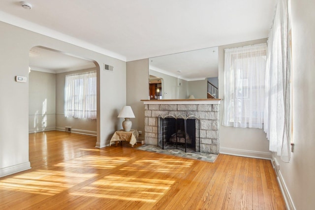 38 Northgate Rd, Riverside, IL 60546 - unfurnished living room featuring hardwood / wood-style flooring, baseboards, a fireplace, and arched walkways