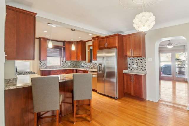 38 Northgate Rd, Riverside, IL 60546 - kitchen with appliances with stainless steel finishes, a peninsula, decorative backsplash, light wood-type flooring, and recessed lighting