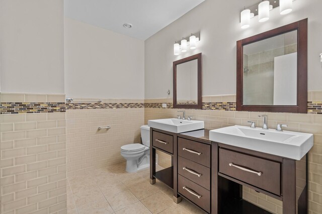 1645 W Ogden Ave Unit 304, Chicago, IL 60612 - full bath featuring double vanity, toilet, tile walls, wainscoting, and tile patterned floors